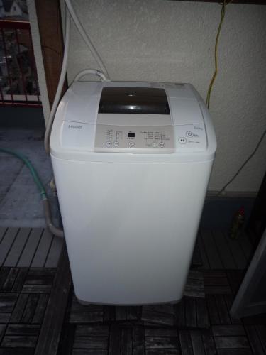 a washing machine sitting on the floor in a room at Osaka Kuma House in Osaka
