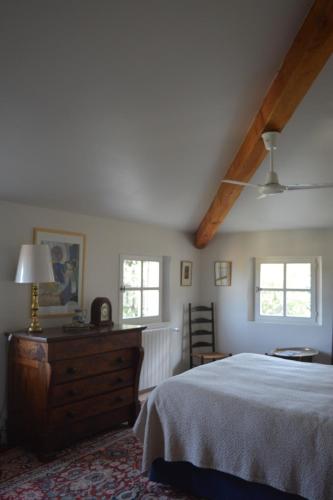 une chambre avec un lit et une commode et deux fenêtres dans l'établissement Annapurna Bed & Breakfast, à Vaison-la-Romaine