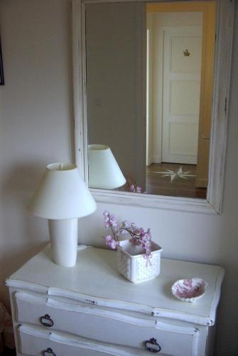 a lamp on top of a dresser with a mirror at Gîte La Bertichère in Saint-Jean-le-Thomas