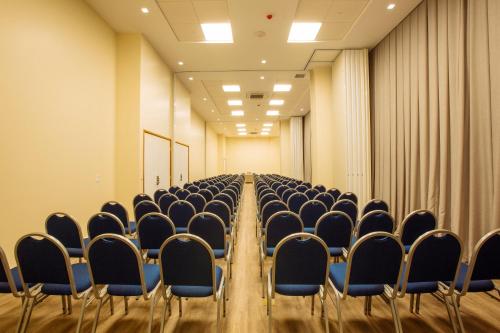 an empty conference room with chairs and curtains at Intercity Suape Costa Dourada in Cabo de Santo Agostinho