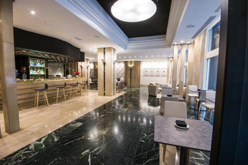 a lobby with a bar and some chairs at Hotel Olid in Valladolid
