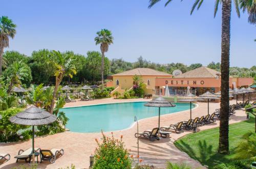 a pool at the resort with chairs and umbrellas at Jardim da Meia Praia Resort in Lagos