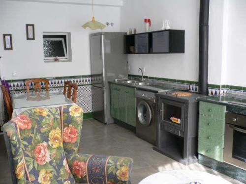 a kitchen with a stove and a washing machine at Apartamentos Isabel in Maro