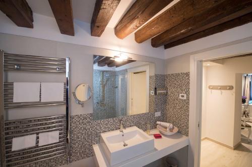 bagno con lavandino e specchio di Savoia e jolanda Apartments a Venezia