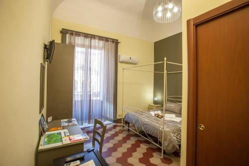a bedroom with a bed and a desk and a table at SiciliaEtnaMare in Riposto