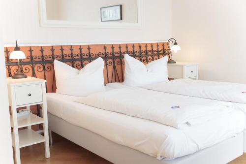 2 łóżka w pokoju hotelowym z białymi poduszkami w obiekcie Cafe´Seestrasse w mieście Magdeburg