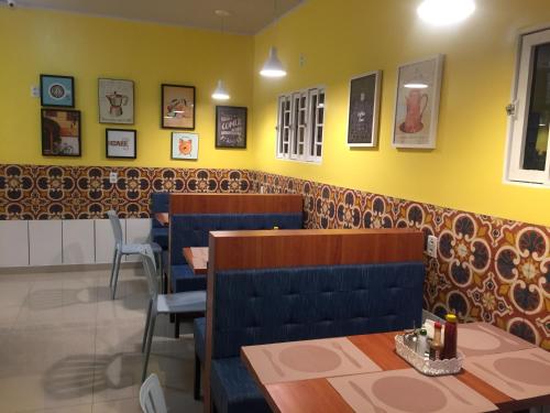 a dining room with tables and chairs and yellow walls at Hotel Caroline in Timon