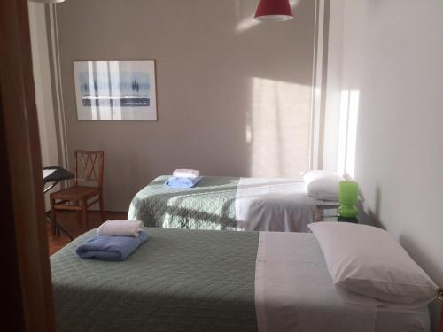 una habitación de hotel con 2 camas y una silla en Casa Salice en Racconigi