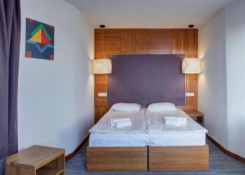a small bedroom with a bed and a table at Valentyna in Lviv