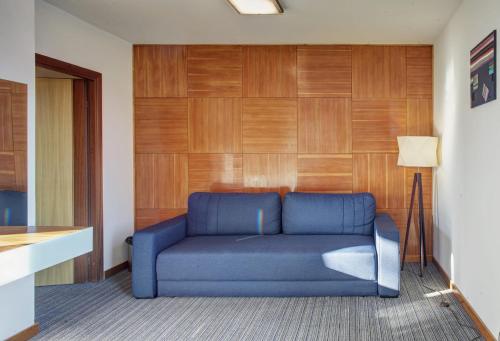 a blue couch in a living room with wooden walls at Valentyna in Lviv