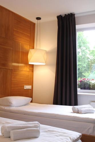 two beds in a room with a window at Valentyna in Lviv