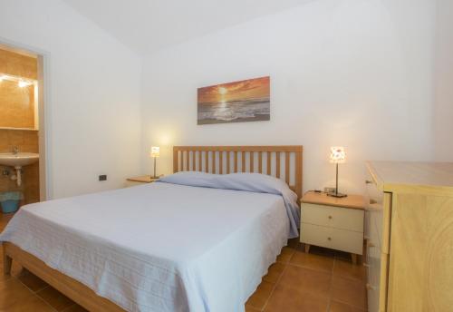 ポルトフェッラーイオにあるVilletta Biodola Beachのベッドルーム1室(ベッド1台付)、2泊分のスタンド(ランプ付)