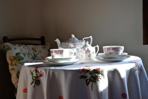 a table with a tea set on top of it at Appartamento con patio privato e giardino tra Pisa e Firenze in Palaia