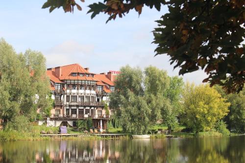 a large building on the side of a lake at Stary Tartak in Iława