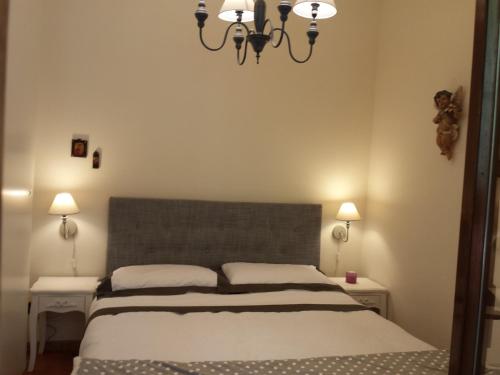 カステル・ディ・サングロにあるAppartamento Golden Parkのベッドルーム1室(ベッド1台、シャンデリア付)