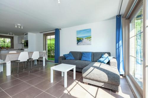 ein Wohnzimmer mit einem Sofa und einem Tisch in der Unterkunft Casa Topsea in De Panne