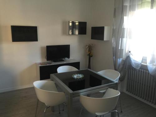 a living room with a table and chairs and a television at Appartamenti Giada in Verona