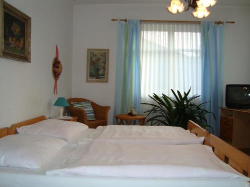 sypialnia z dużym białym łóżkiem i oknem w obiekcie Villa Olivia w Pradze