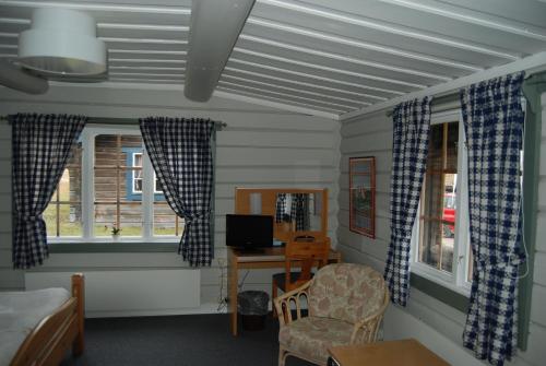 a room with a desk with a computer and two windows at Dala Wärdshus in Rättvik