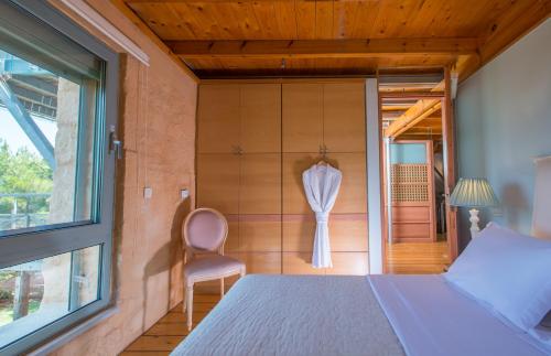 a bedroom with a bed and a chair and a window at Olea Prime in Marathi