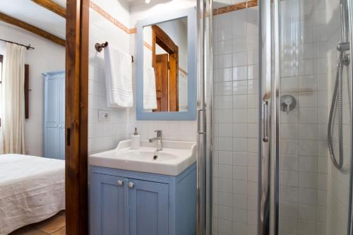 y baño con lavabo y ducha. en Antiche Case in Pietra, en Baunei
