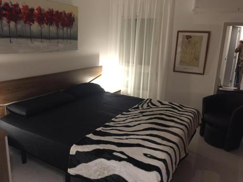 un letto con stampa zebra in una camera da letto con sedia di Apartment Casaluthel Boulevard a Torrox Costa