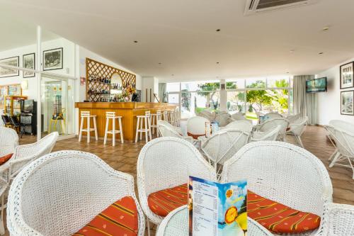 a room with white wicker chairs and a table at Pateo Village in Albufeira
