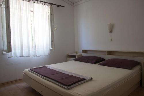 Schlafzimmer mit einem großen weißen Bett und einem Fenster in der Unterkunft Apartman Pavletic in Starigrad