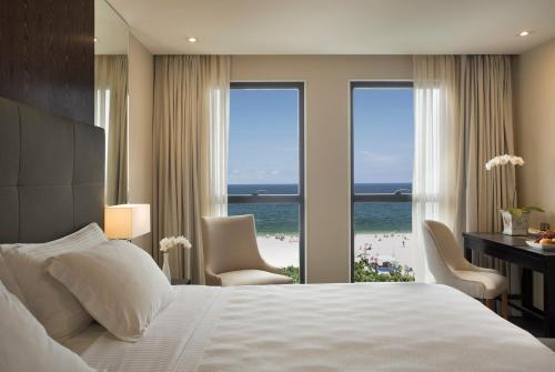 a hotel room with a bed and a view of the beach at Windsor California Copacabana in Rio de Janeiro