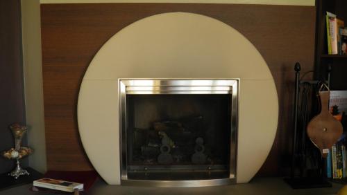 a fireplace in a living room with a mirror at Logis de Ponthus in Paimpont