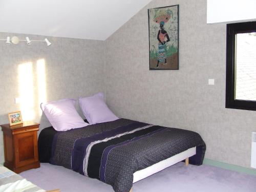 ein Schlafzimmer mit einem Bett und einem Bild an der Wand in der Unterkunft Logis de Ponthus in Paimpont