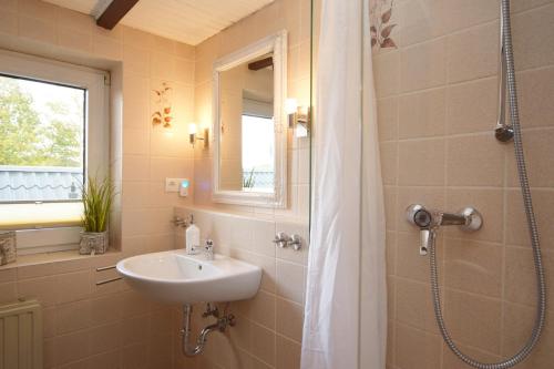 een badkamer met een wastafel en een douche bij Ferienwohnung Ostseelys in Glücksburg