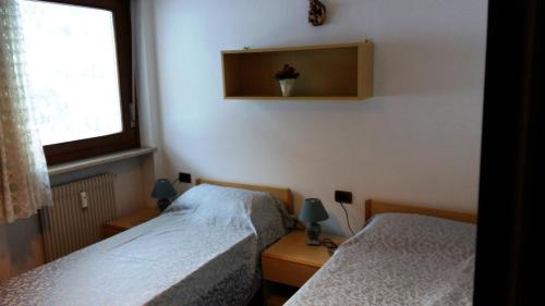 オルティゼーイにあるAppartamento Gardeniaのベッドルーム1室(ベッド2台、窓付)