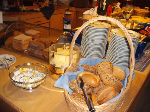 a basket of bread and plates on a counter at Hotel Pension Loose in Borkum