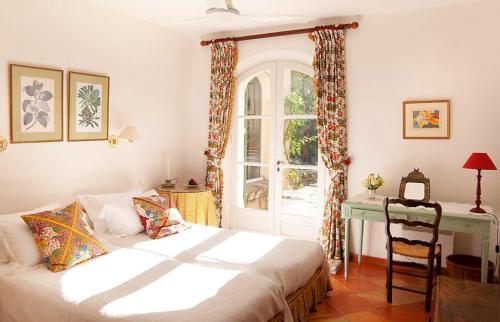 a bedroom with a bed and a desk and a window at Villa Elaiza in Saint-Tropez