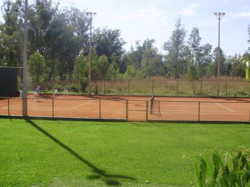 two people playing tennis on a tennis court at Ruta Del Sol in Ypacarai