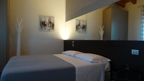 a bedroom with a bed with two pillows and a mirror at Magrine Castelfranco Veneto in Castelfranco Veneto