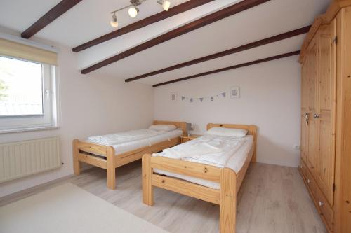 Cette chambre comprend 2 lits et une fenêtre. dans l'établissement Ferienwohnung Ostseelys, à Glücksburg
