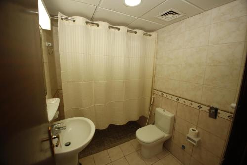 a small bathroom with a toilet and a sink at Guest Time Hotel in Al Madinah