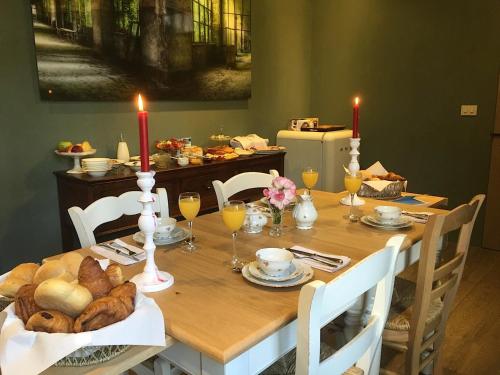 einen Esstisch mit einem Tisch mit Brot und Kerzen in der Unterkunft de Gasterie in Koksijde