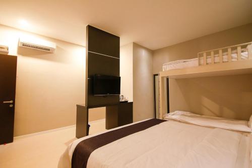a bedroom with a bunk bed with a television at Art Cottage Hotel in Ipoh