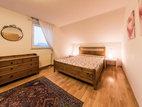 een slaapkamer met een bed, een ladekast en een spiegel bij Ferienhaus Schröder Kalterherberg in Monschau