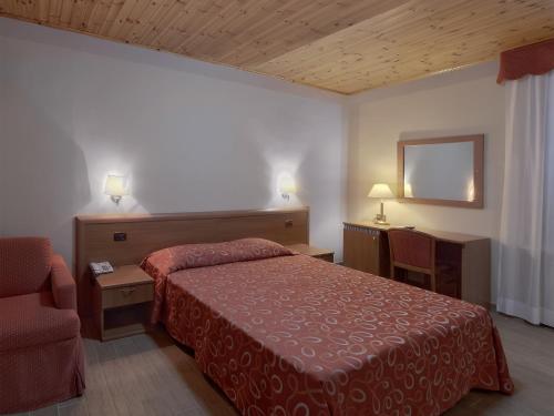Habitación de hotel con cama y silla en Terme Di Monte Valenza, en Valenza