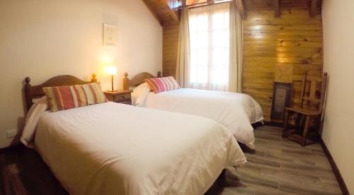 a bedroom with two beds and a window at Cabañas Woodland in San Martín de los Andes