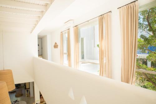 a white staircase in a house with a large window at Kalá Hotel Boutique in Punta del Este