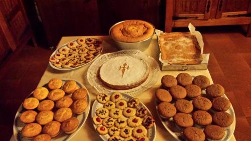 un tavolo pieno di torte e altri dolci e torte di Casa da Torre a Valga