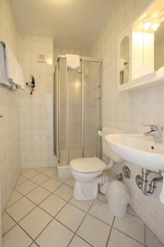 a bathroom with a toilet and a sink and a shower at Aparthotel Berlin in Bad Nenndorf
