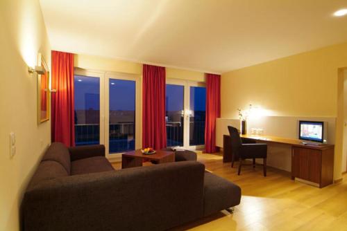 a living room with a couch and a desk with a computer at Trend Hotel in Banzkow