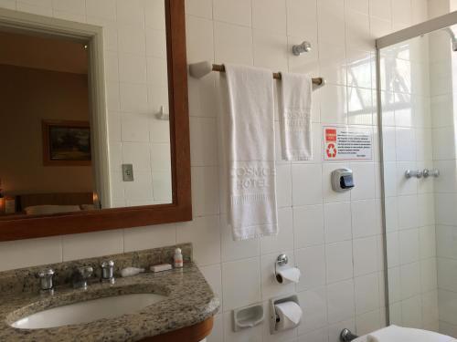 uma casa de banho com um lavatório e um espelho em Cosmos Hotel em Caxias do Sul