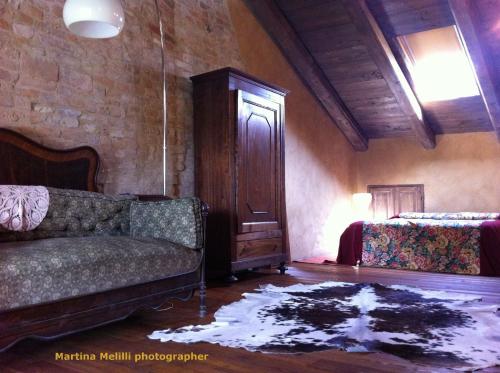 a living room with a couch and a bed at La Corte del Barbio in Aramengo